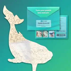 Puzzle ragasztó készlet csomag tartalma bálnás kirakóval, zöld háttér előtt.